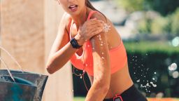 Young woman cooling with water after sports training.