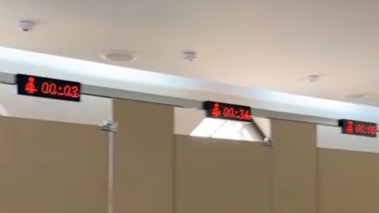 A screenshot from a video shows timers above the stalls in a restroom at the Yungang Buddhist Grottoes.