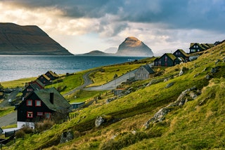 KirkjubÃ¸ur and Koltur at Foaroe Islands. Traditional black tarred timber and grass roofs.