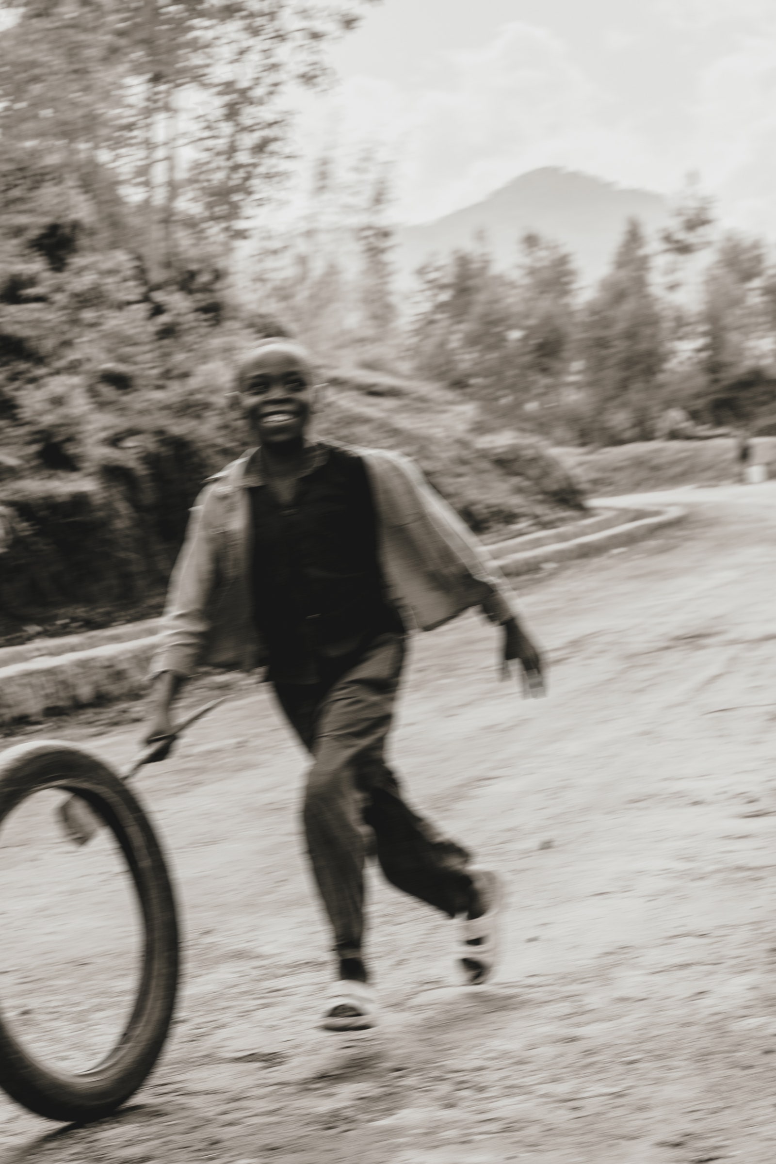 A child rolls a hoop along the road to Wilderness Bisate lodge