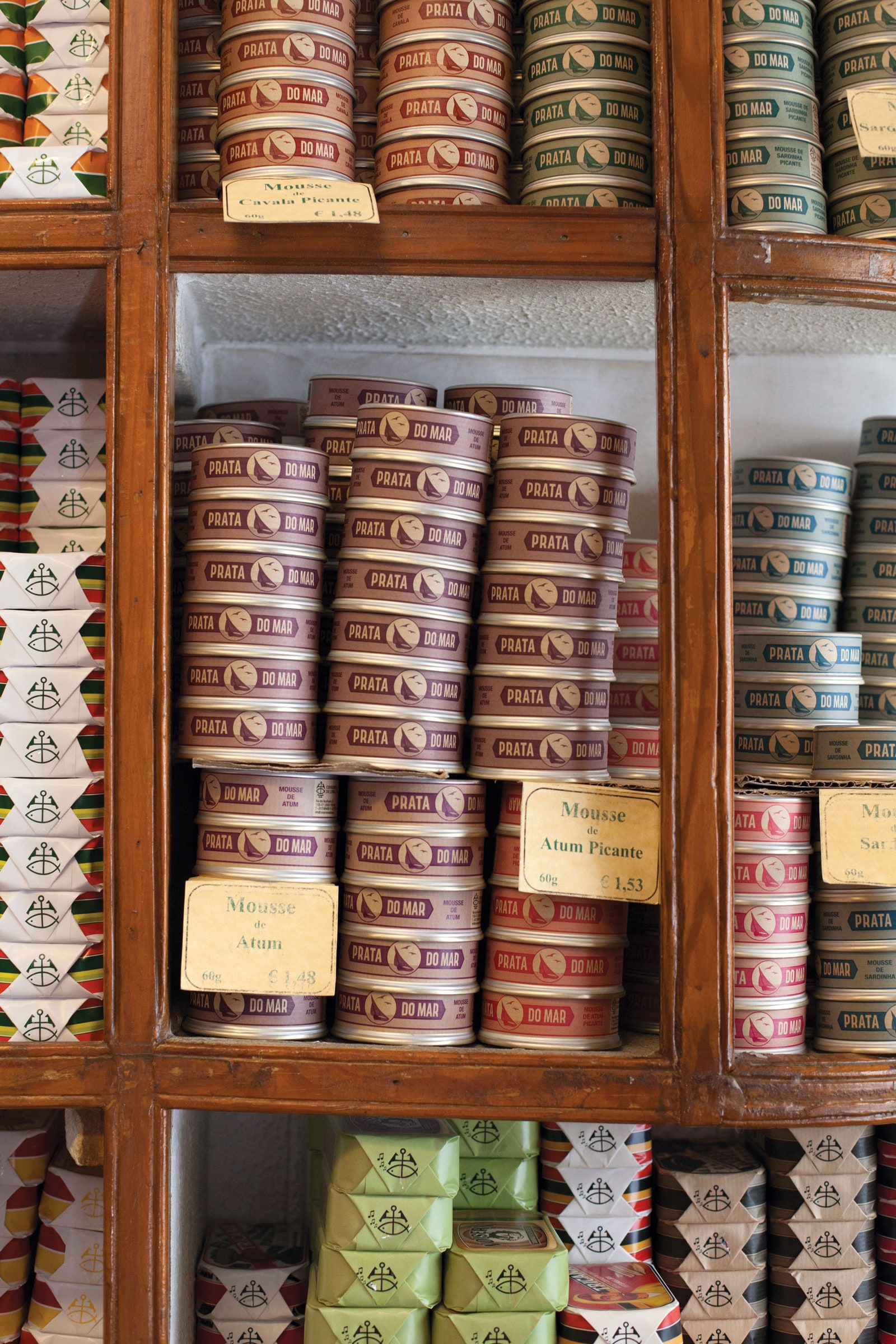 shelves tightly packed with tins of different types of tuna mousse