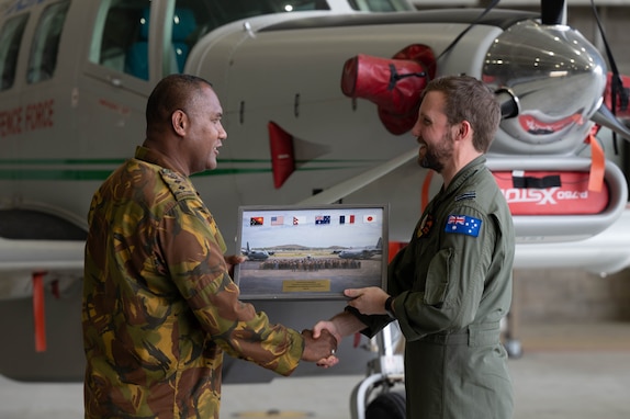 Papua New Guinea Defence Force Col. Craig Solomon (left), Air Wing commander, presents a gift to Royal Australian Air Force personnel at the closing ceremony for Pacific Angel 24-1 at Port Moresby, Papua New Guinea, Aug. 30, 2024.