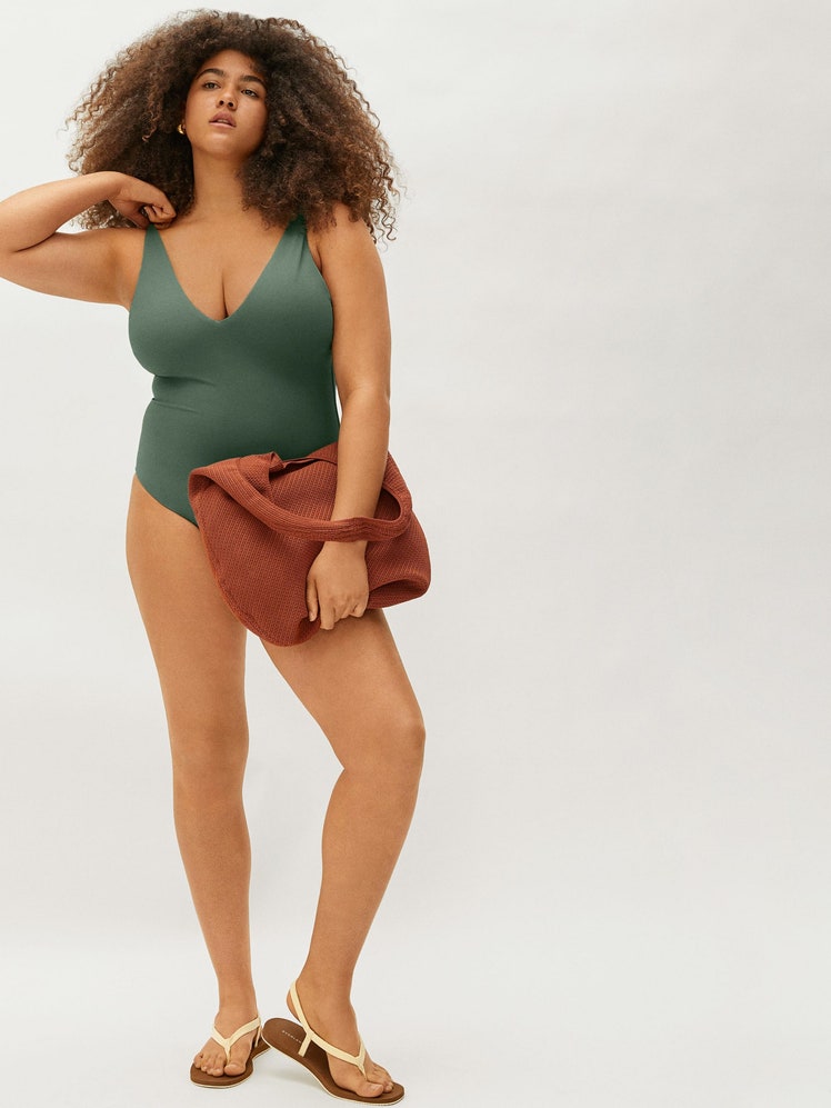 model wearing green one piece swimsuit