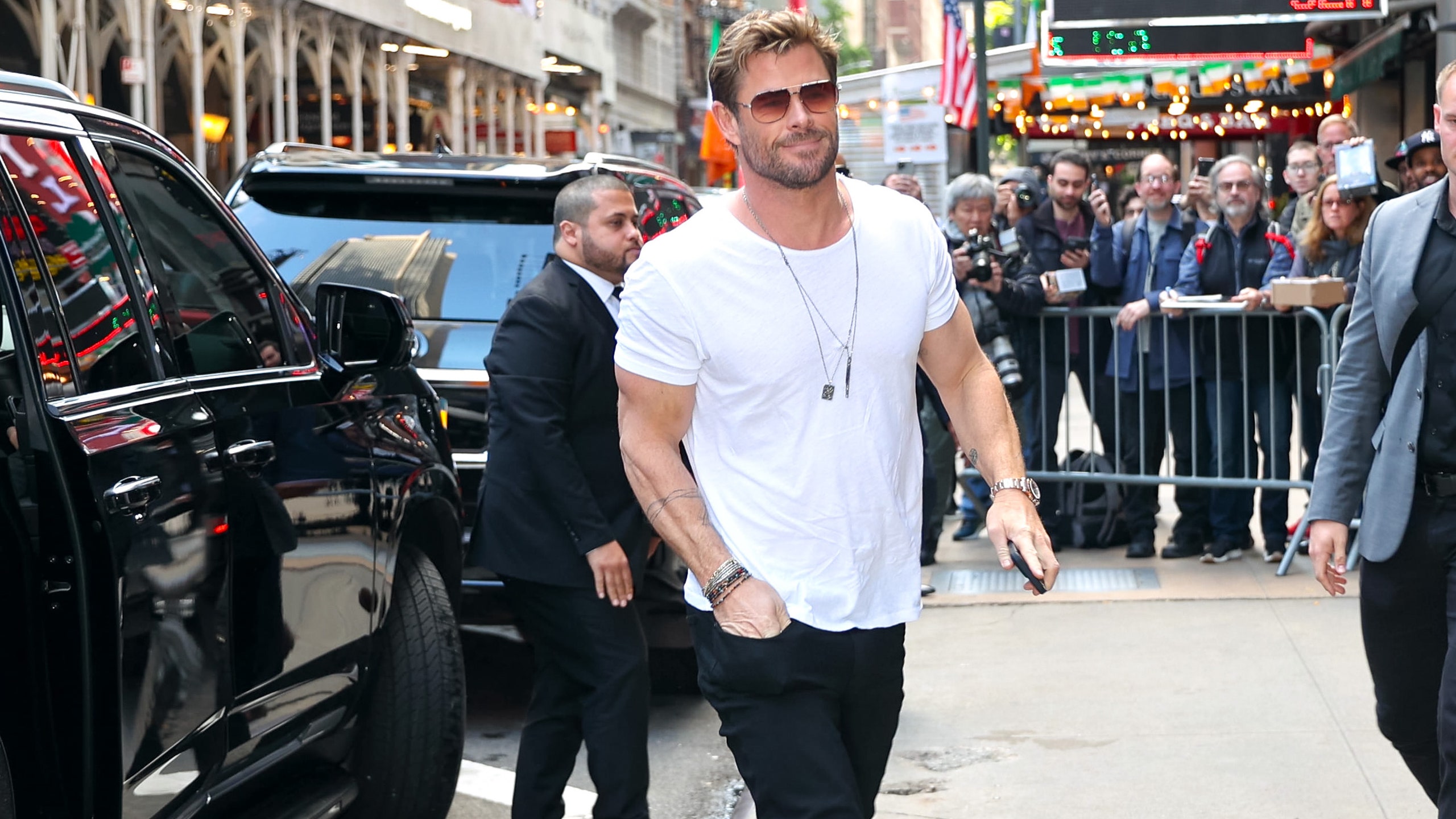 Chris Hemsworth usando pantalones de mezclilla con botas y playera