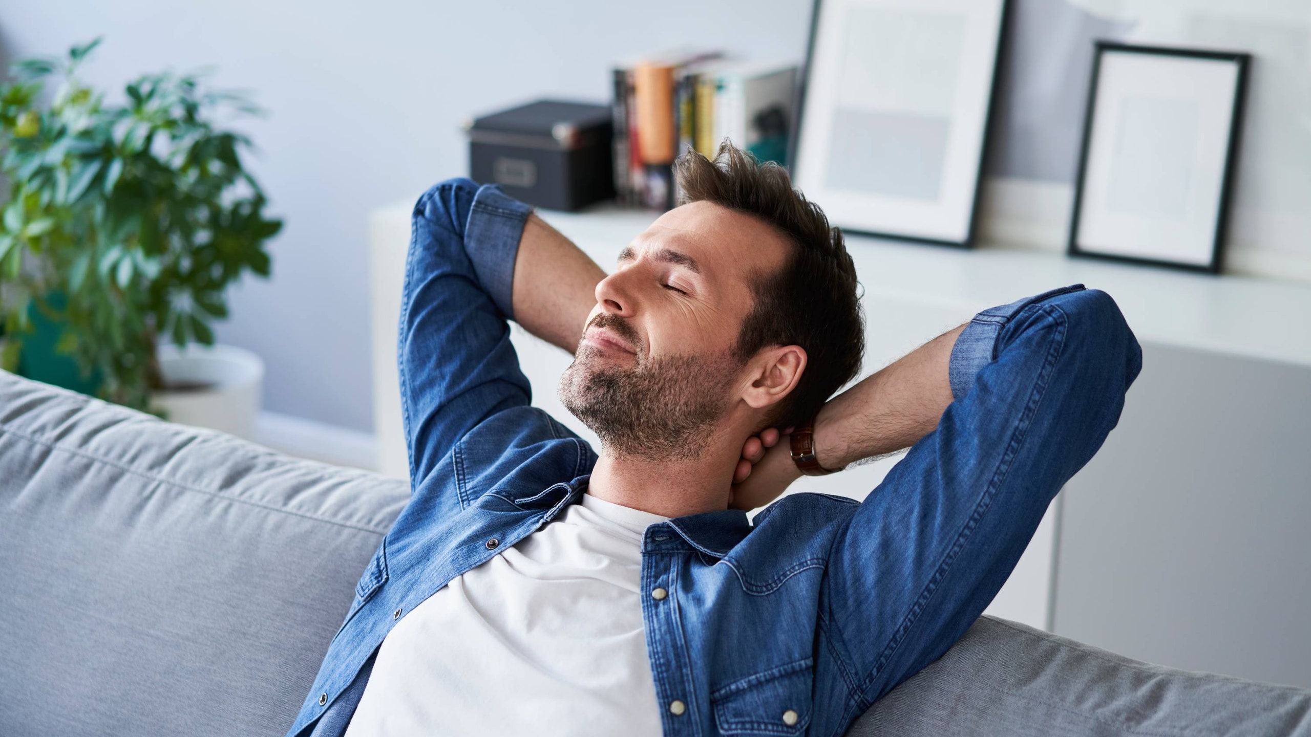 Hombre descansando en el sillón de su casa concepto de modo vacaciones.