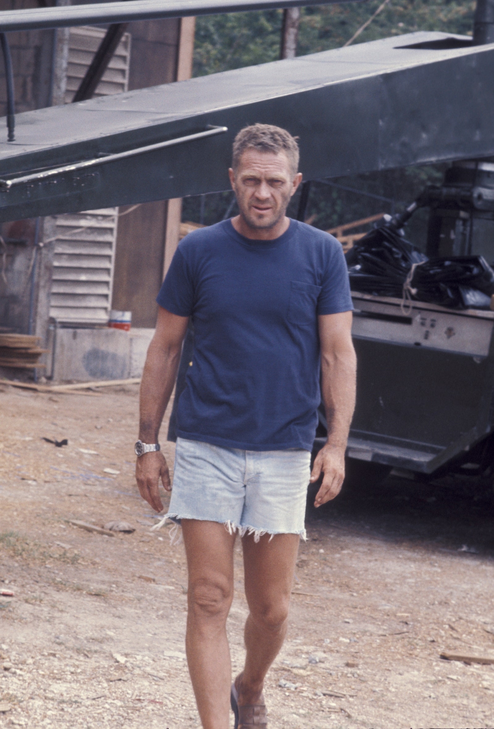 Image may contain Steve McQueen Clothing Shorts Wristwatch Adult Person Beachwear Standing Footwear and Shoe