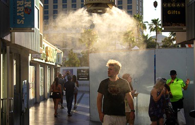 People walk through misters along the Las Vegas Strip, Sunday, July 7, 2024, in Las Vegas. The city set an all time record high of 120 F (48.8 C) Sunday as a heat wave spread across the Western U.S. sending many residents in search of a cool haven from the dangerously high temperatures.