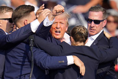 Republican presidential candidate former President Donald Trump is helped off the stage by U.S. Secret Service agents at a campaign event in Butler, Pa., on Saturday, July 13, 2024. (AP Photo/Gene J. Puskar)