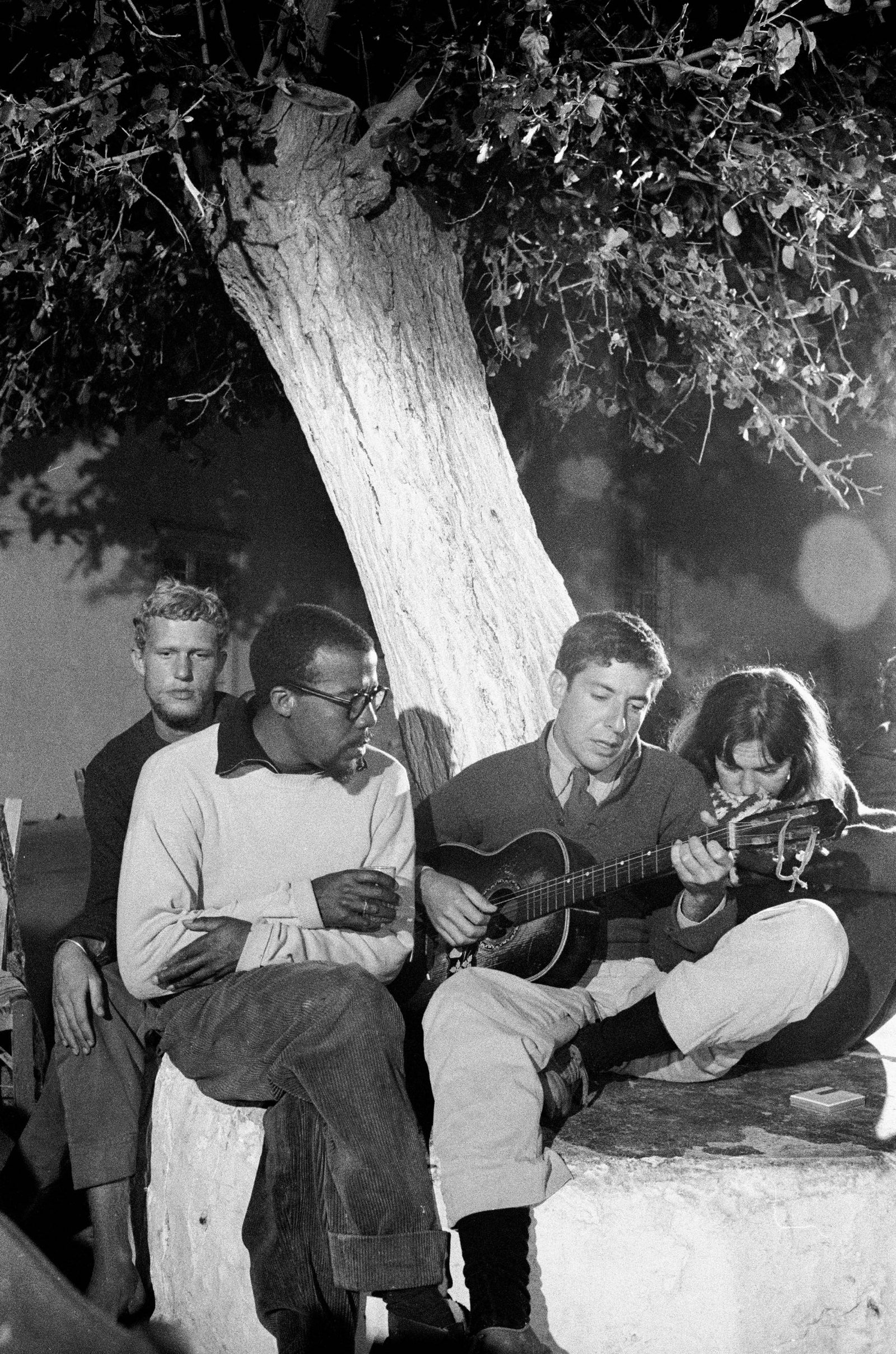 Cohen playing guitar at Douskos Taverna in Hydra Greece in 1960. Hydra promised the life Cohen craved spare rooms the...