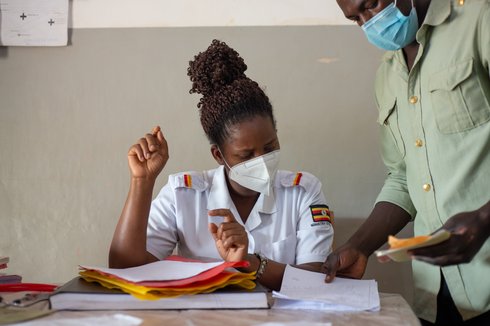 The Midwife in Charge checks the medical records of a patient at Mpigi Health Centre IV in Mpigi Town, Uganda. Photo: PATH/Will Boase.