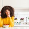 Purchased - Woman sitting at table eating fruit