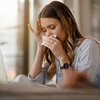 Woman blowing her nose not feeling well