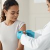 Purchased - A young woman getting vaccinated at the doctor's office