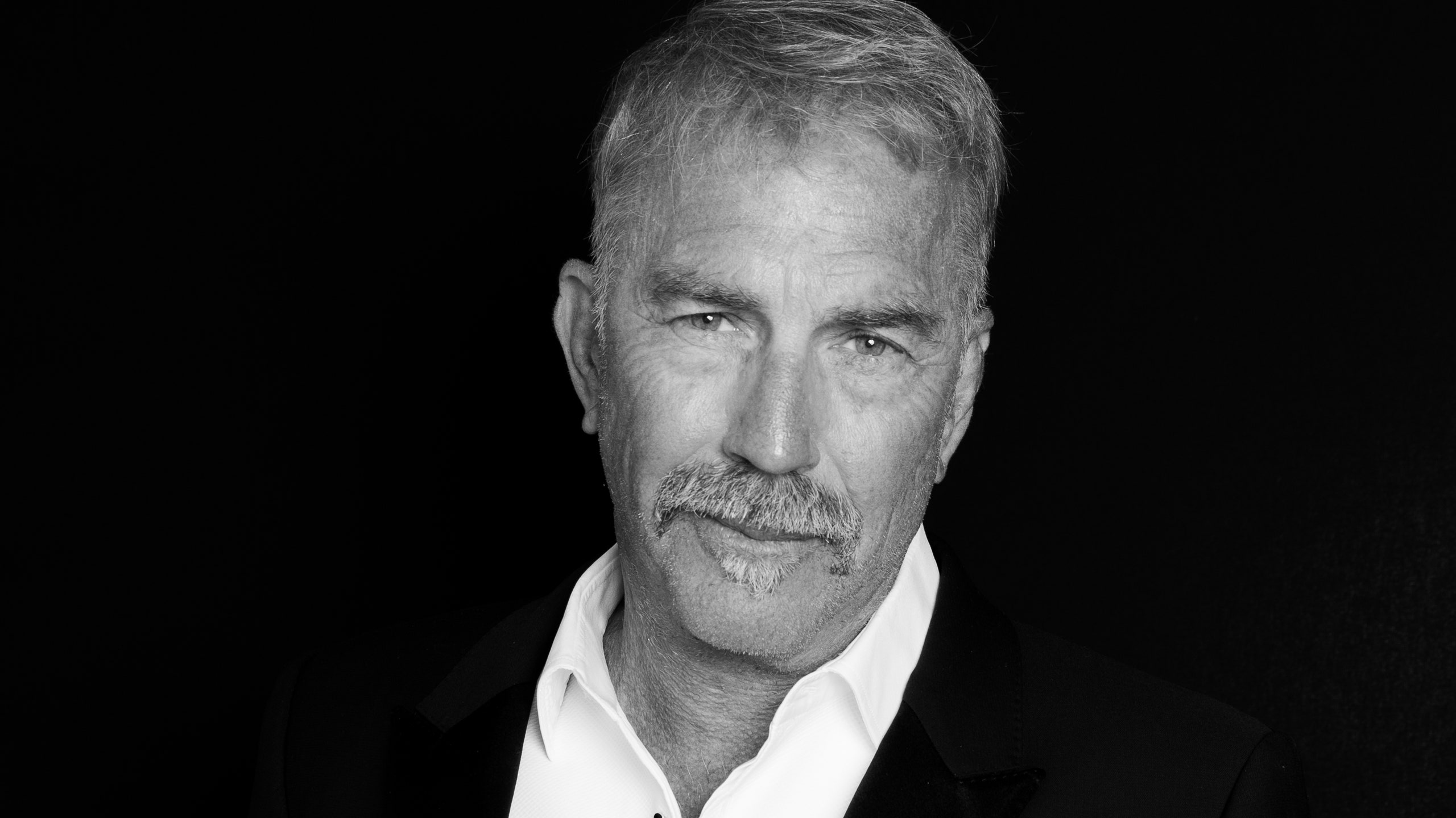 Image may contain Kevin Costner Clothing Formal Wear Suit Face Head Person Photography Portrait and Body Part