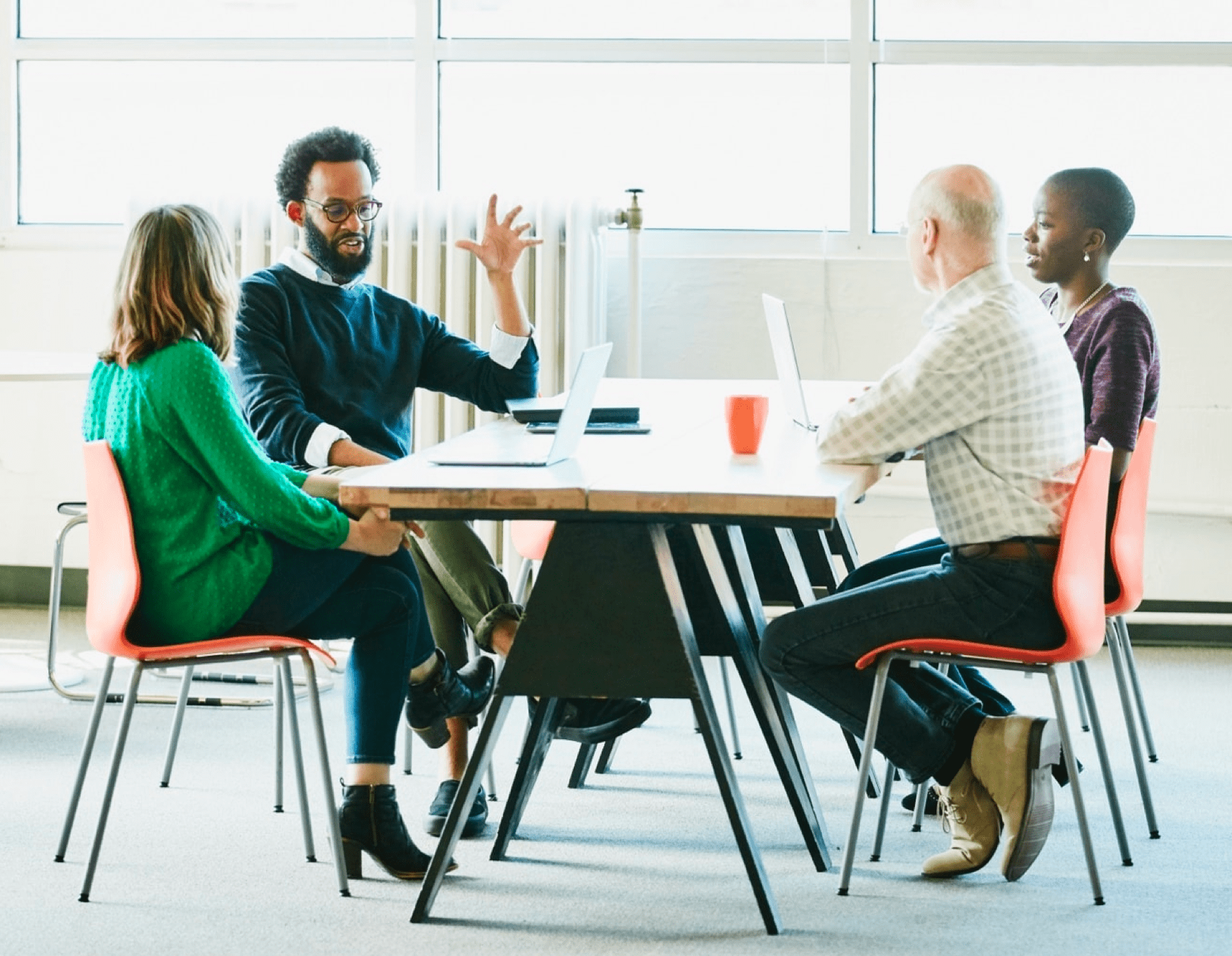 Men and women in coversation at office table