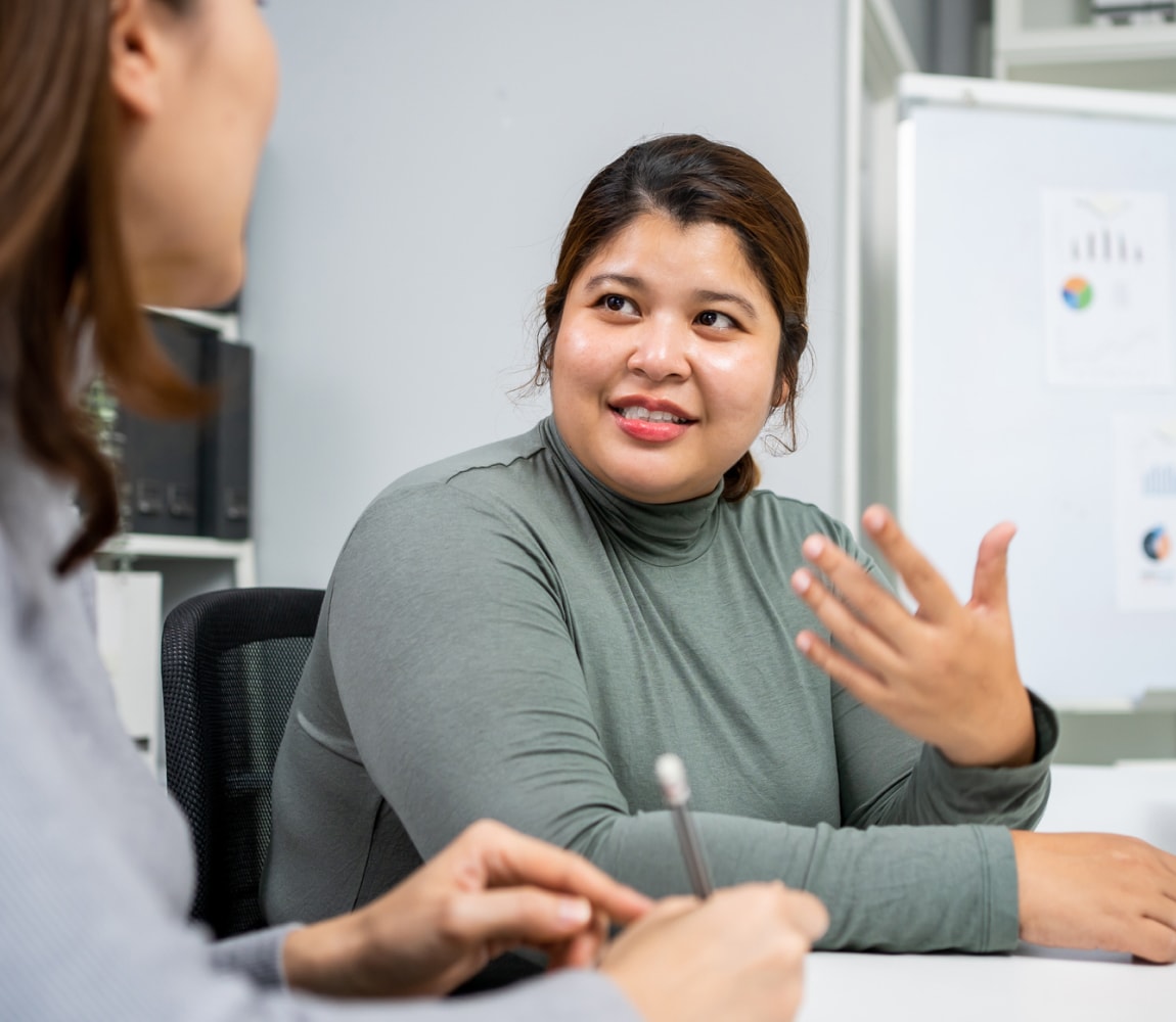 Men and women in coversation at office table