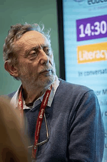 a man wearing glasses and a lanyard that says ' literacy ' on it