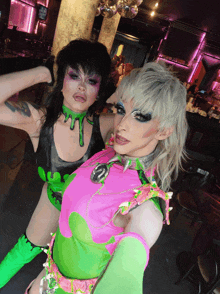 two drag queens posing for a photo in a club