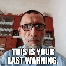 a man with glasses and a beard has a caption that says this is your last warning