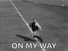 a black and white photo of a man running with a football with the words on my way below him