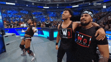 two wrestlers are posing for a picture with one wearing a shirt that says wo on it