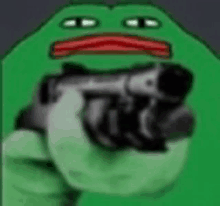 a green frog is holding a gun and pointing it at the camera .