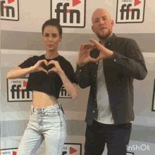 a man and a woman are making a heart shape with their hands in front of a radio ffn sign