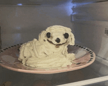 a dog made out of whipped cream is on a plate