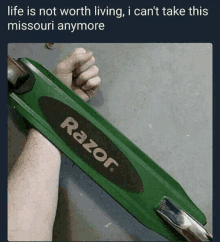 a person is holding a razor scooter in their hand .