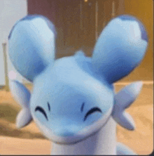 a close up of a blue and white axolotl with ears and a smile on its face .