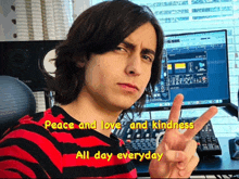 a young man giving a peace sign in front of a computer with the words peace and love and kindness all day everyday