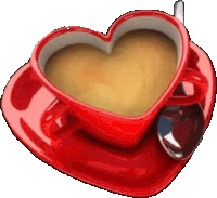 a heart shaped cup of coffee sits on a saucer with a spoon