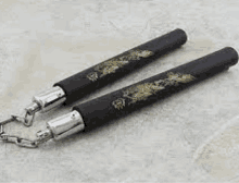 a pair of black nunchaku with a dragon design on them are sitting on a table .