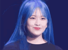 a woman with blue hair and red lipstick is smiling .