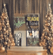 a book called teache tales sits on a table in front of christmas trees