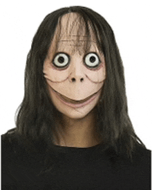 a woman wearing a momo mask with big eyes and a smiling face .