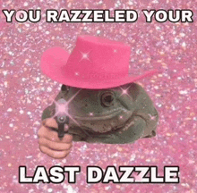 the frog is wearing a pink hat and holding a gun .