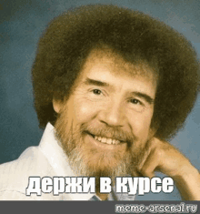 a man with a beard and a big afro is smiling in russian