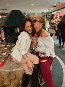 a woman kisses another woman on the cheek