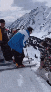 a group of people skiing on a snowy mountain with a man wearing a blue jacket that says cc on it