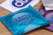 a close up of three packages of durex condoms on a table .