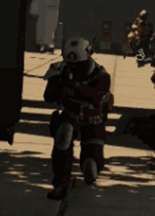 a man in a red suit with a white helmet with a red cross on it