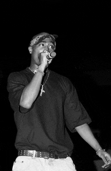 a man singing into a microphone with a cross necklace