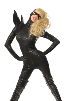 a woman in a black sequined catsuit and black boots