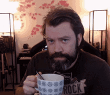 a man with a beard is holding a mug that says rock