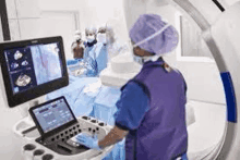 a surgeon is operating on a patient in an operating room with a computer .