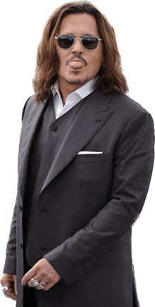 a man with long hair wearing sunglasses and a suit is sticking his tongue out