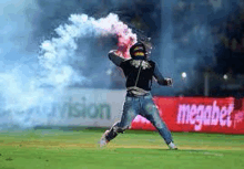 a man is holding a red and white flare on a soccer field .