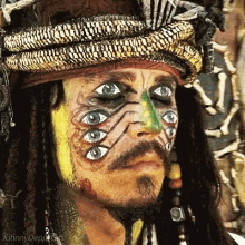 a man with many eyes painted on his face has the name johnny depp on the bottom