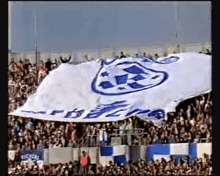 a crowd of people watching a soccer game with a large blue and white banner that says ' rescue '